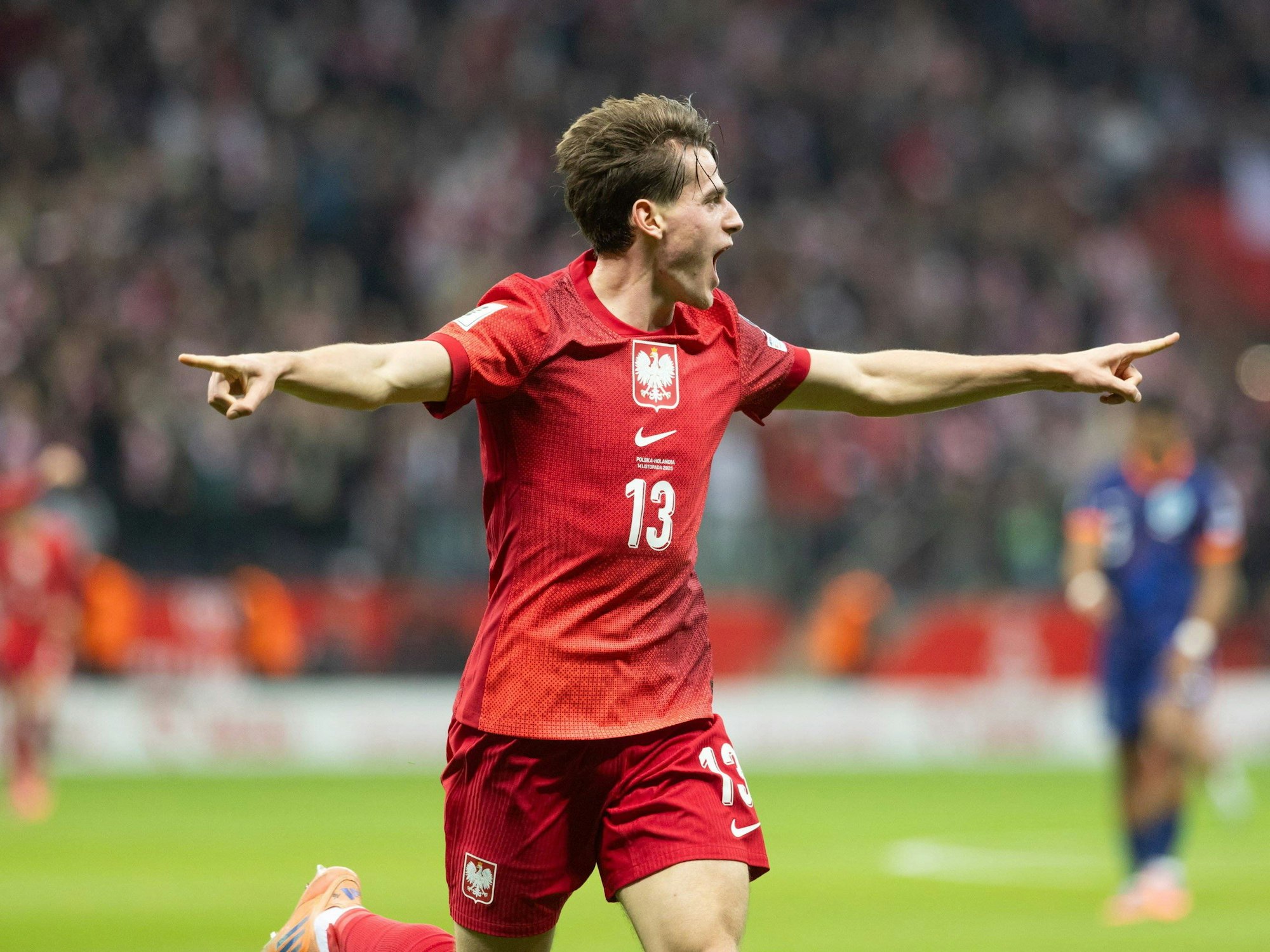 Jakub Kaminski bejubelt seinen Treffer gegen die Niederlande und breitet seine Arme aus.