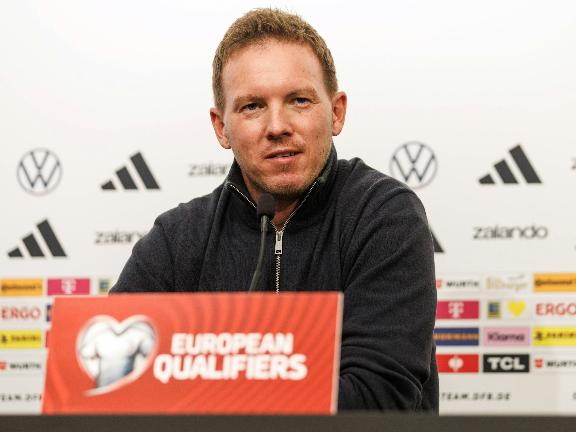 Julian Nagelsmann sitzt bei der Pressekonferenz.