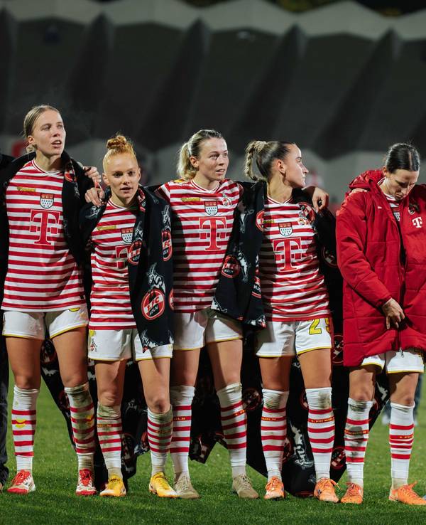 Die Frauen des 1. FC Köln stehen nach einem Spiel Arm in Arm zusammen.