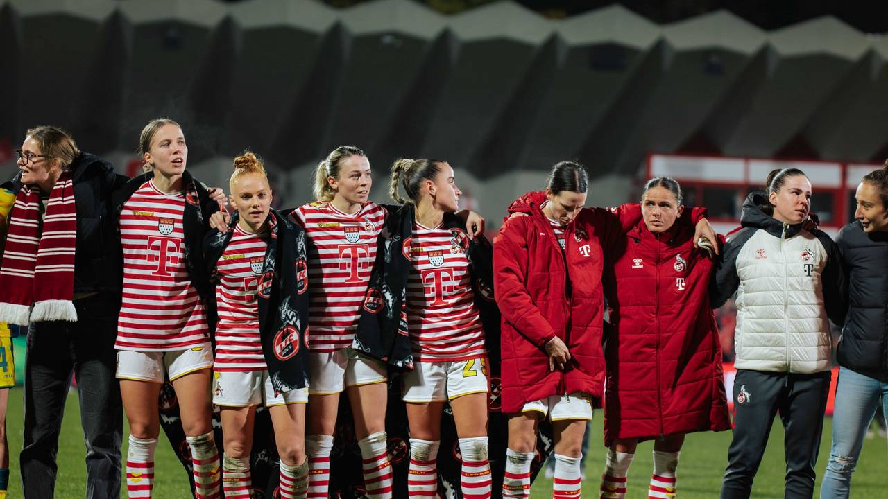 Die Frauen des 1. FC Köln stehen nach einem Spiel Arm in Arm zusammen.