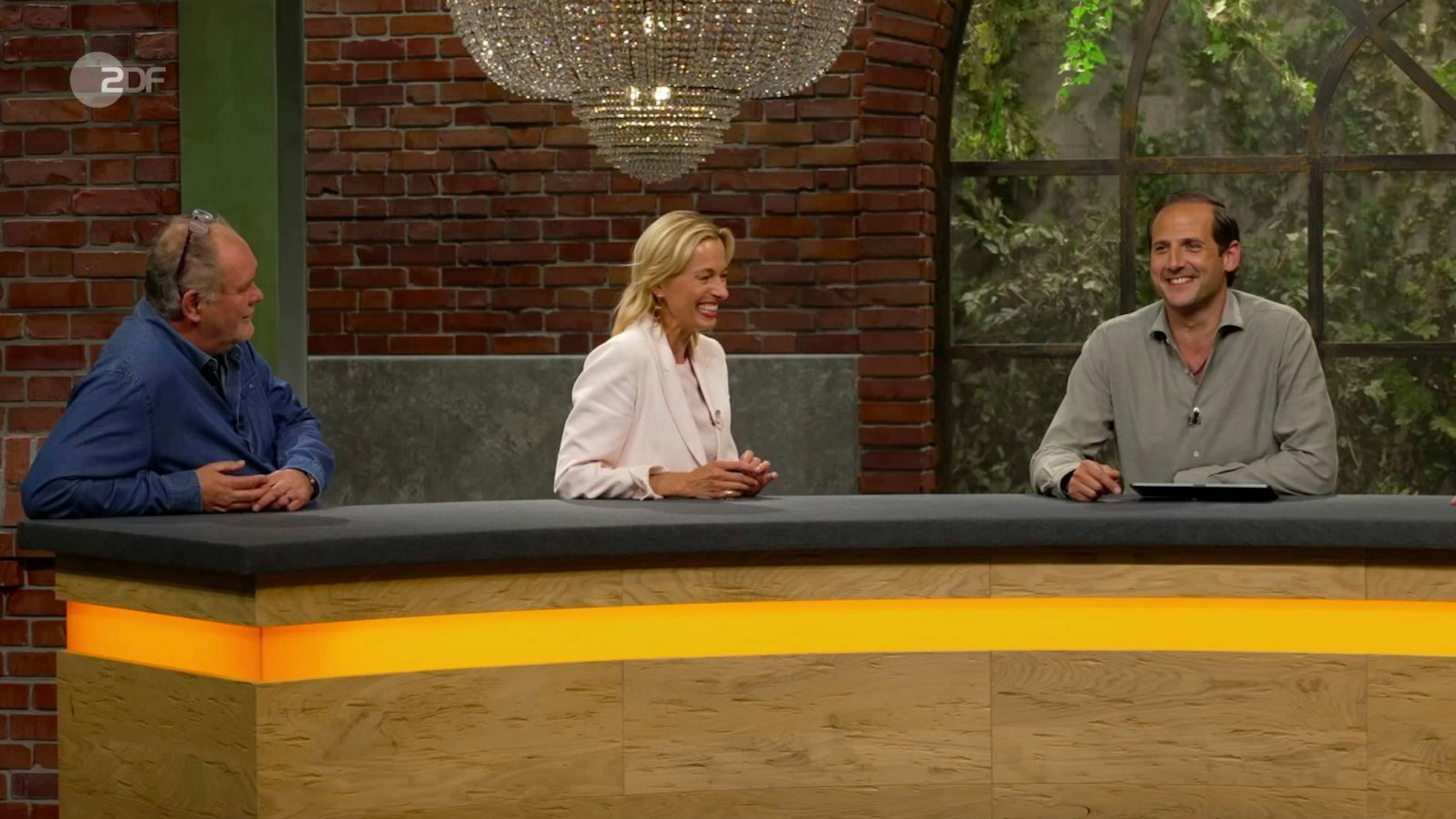 Nach dem Verkauf begann Schmitz-Avila zu schmunzeln, denn „20 Jahre unfallfrei“ wie seine Kollegin Nüdling hatte er leider nicht geschafft. Und so beichtete er: „Den einzigen Unfall, den ich je hatte, war hier auf dem Parkplatz vom Pulheimer Walzwerk - da bin ich Lisa ins Auto gefahren.“ Die Runde brach erneut in Gelächter aus ... (Bild: ZDF)