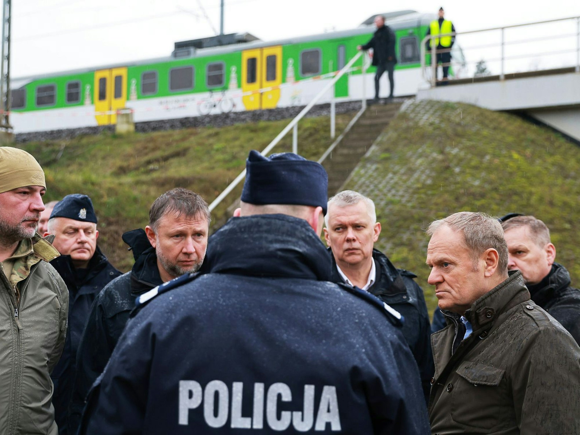 Polens Ministerpräsident Donald Tusk (2.v.r) besichtigt die durch Sabotage beschädigte Eisenbahnstrecke unweit der Ortschaft Mika.