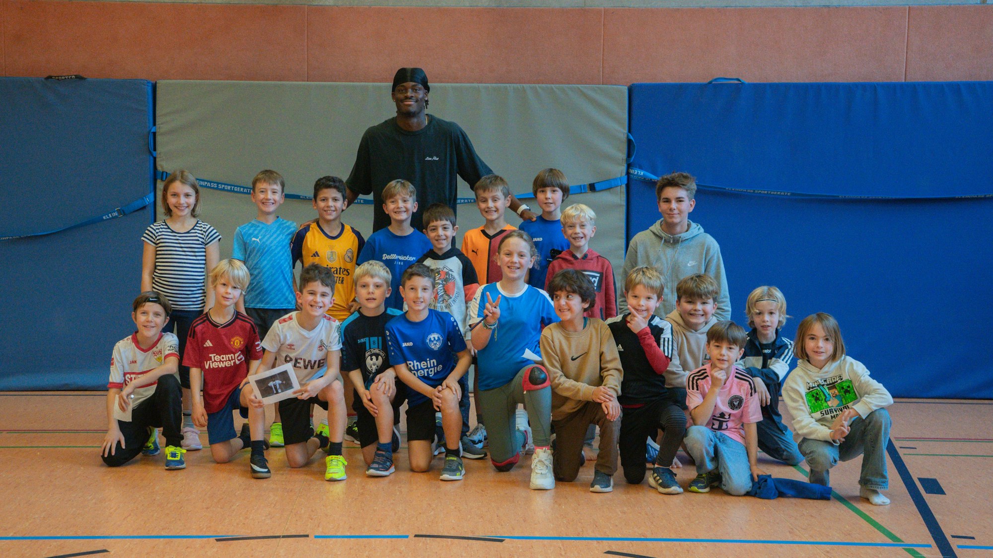 Yann-Aurel Bisseck bei einem Gruppenfoto mit vielen Kindern an seiner alten Schule.