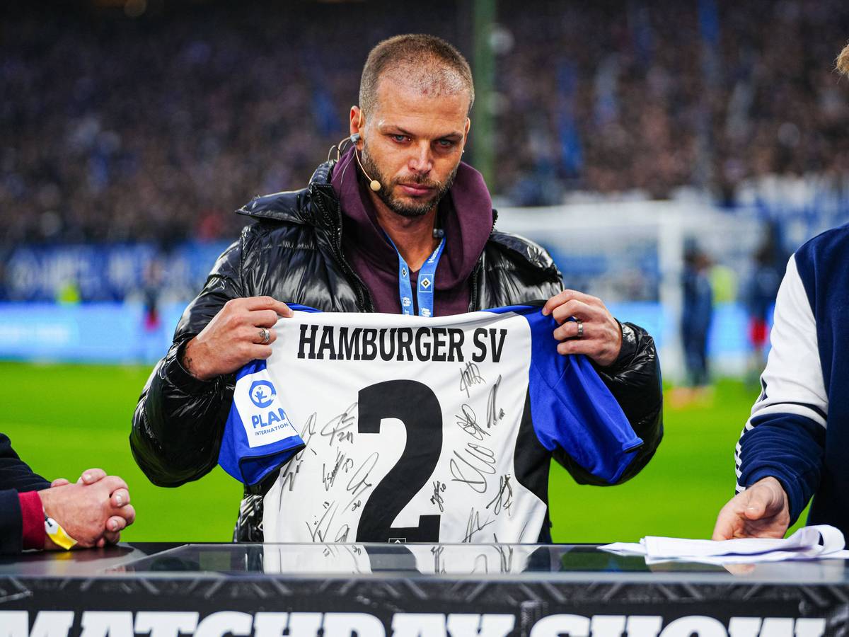 Dennis Diekmeier hält ein unterschriebenes HSV-Trikot hoch und hat dabei Tränen in den Augen.