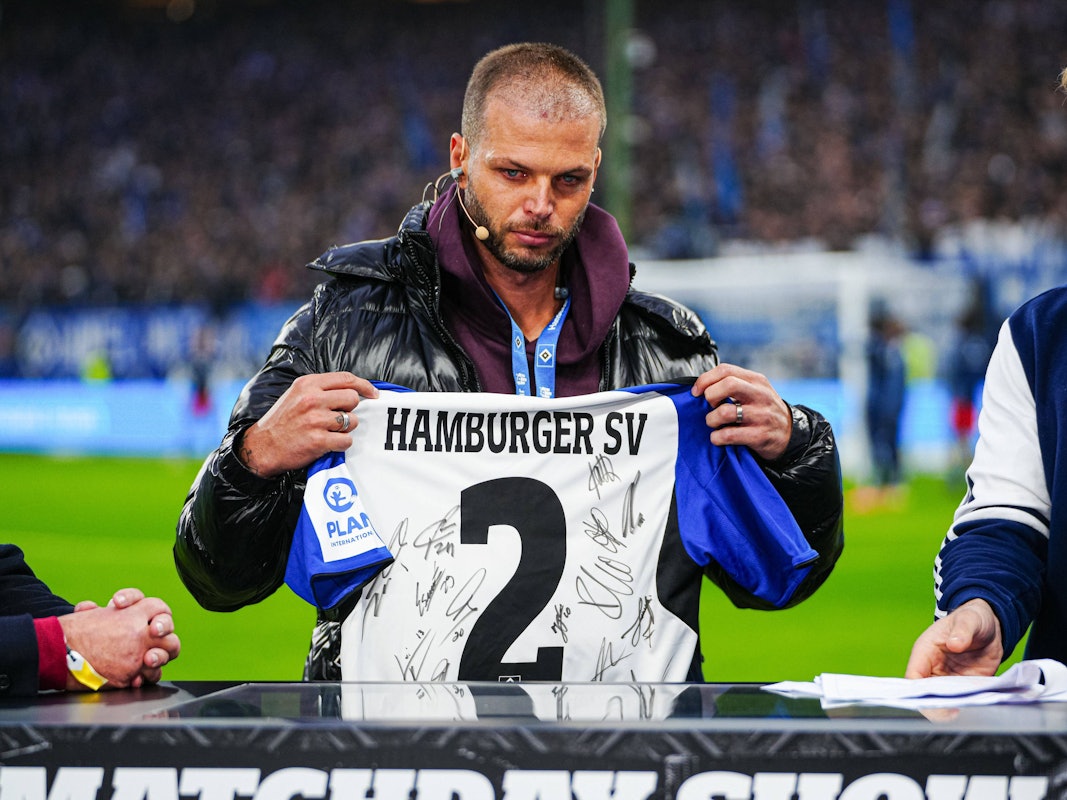 Dennis Diekmeier hält ein unterschriebenes HSV-Trikot hoch und hat dabei Tränen in den Augen.
