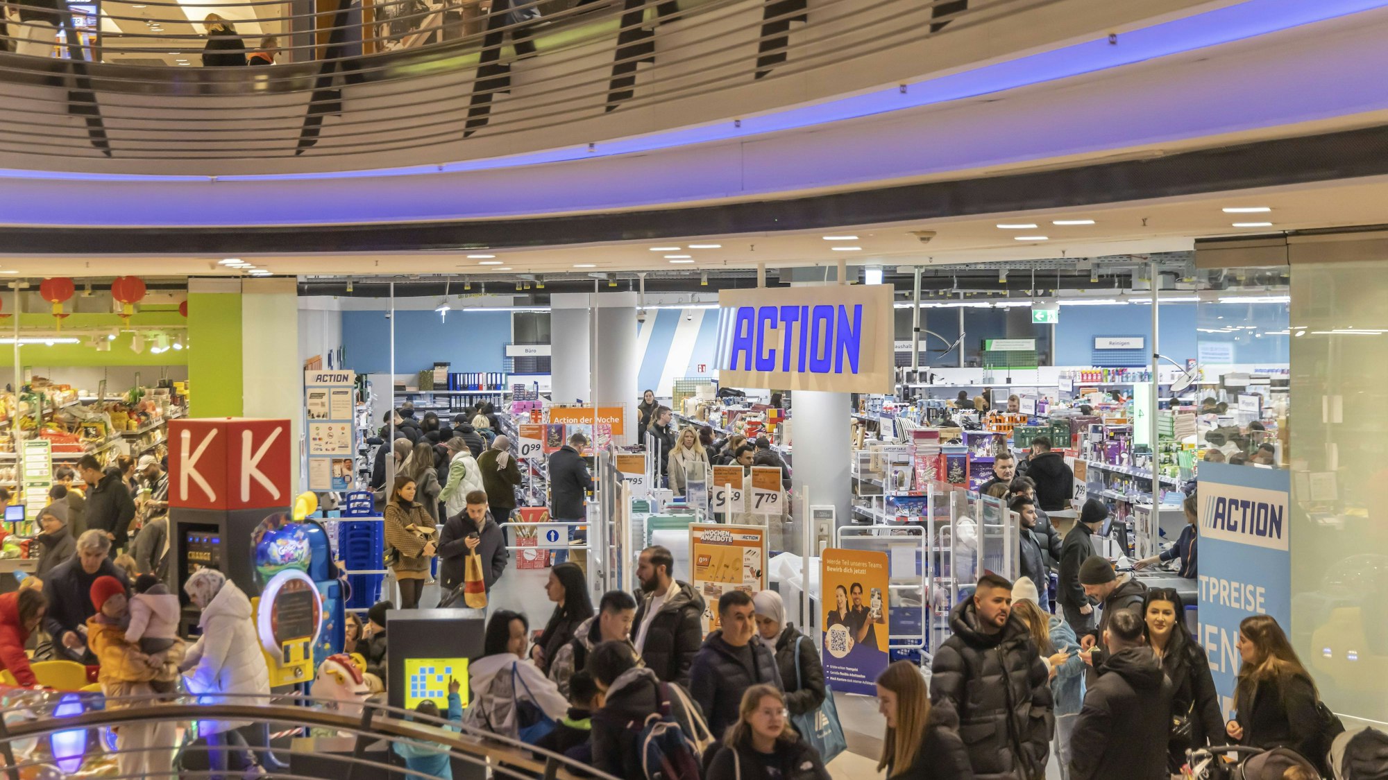 Geschäftiges Treiben in einem Einkaufszentrum mit vielen Menschen und einem Action-Markt