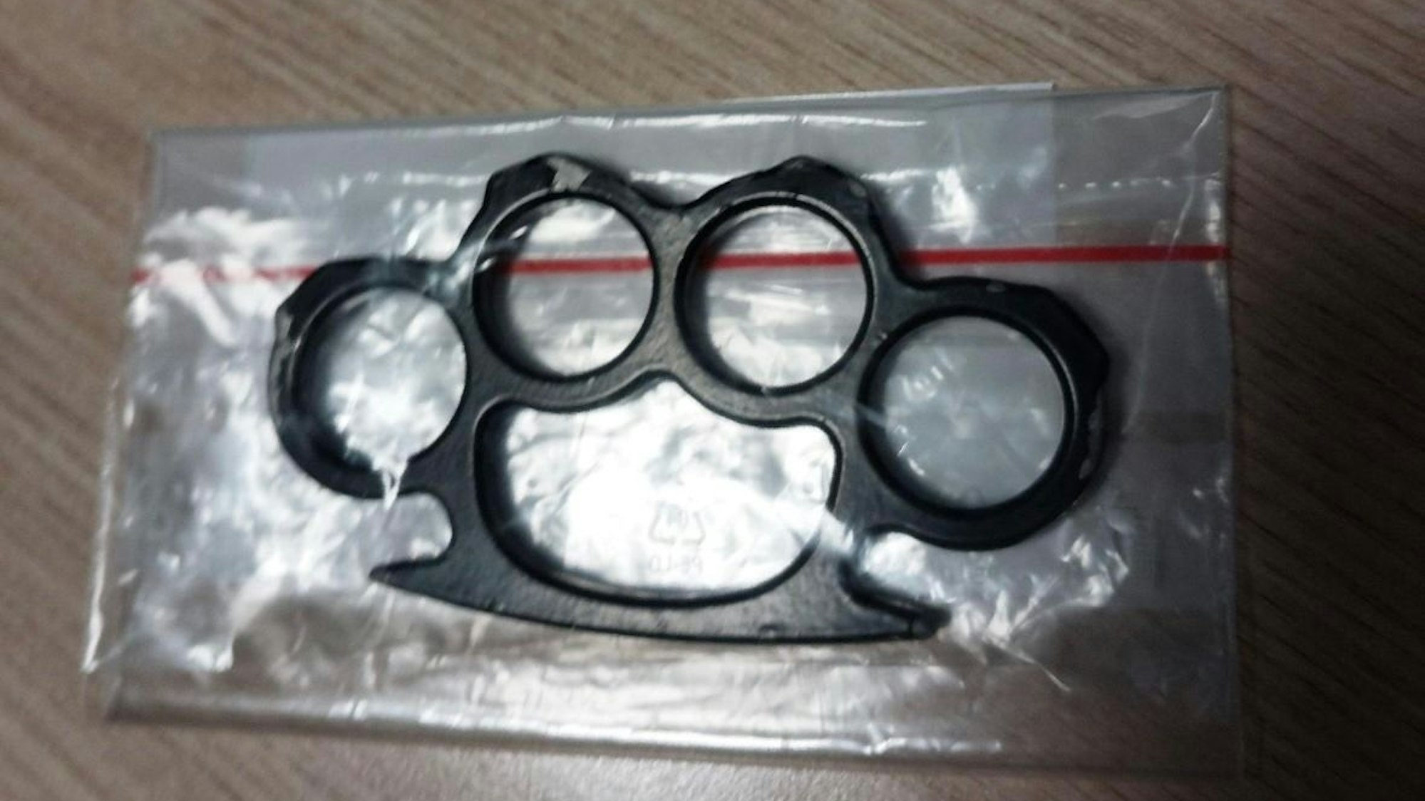 Ein sichergestellter Schlagring liegt auf einem Tisch.