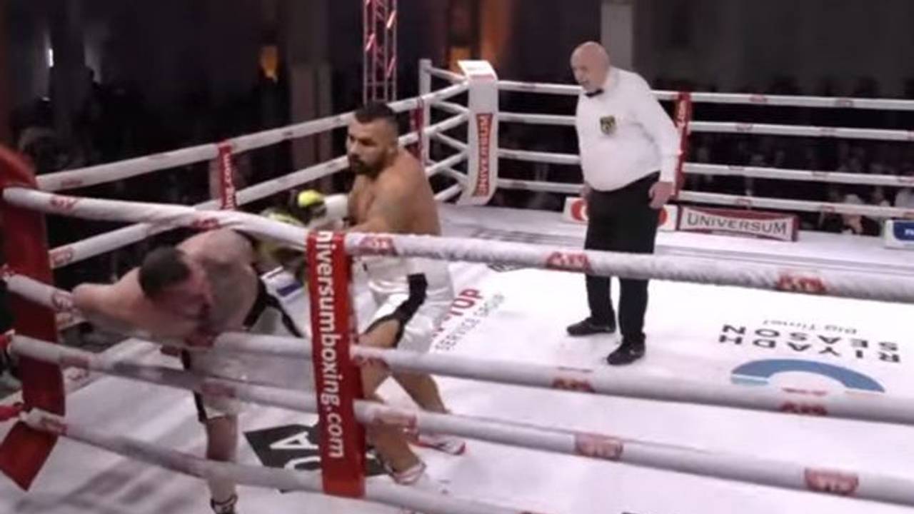 In einem Boxring schlägt ein Mann einen anderen, der bereits in den Seilen hängt.