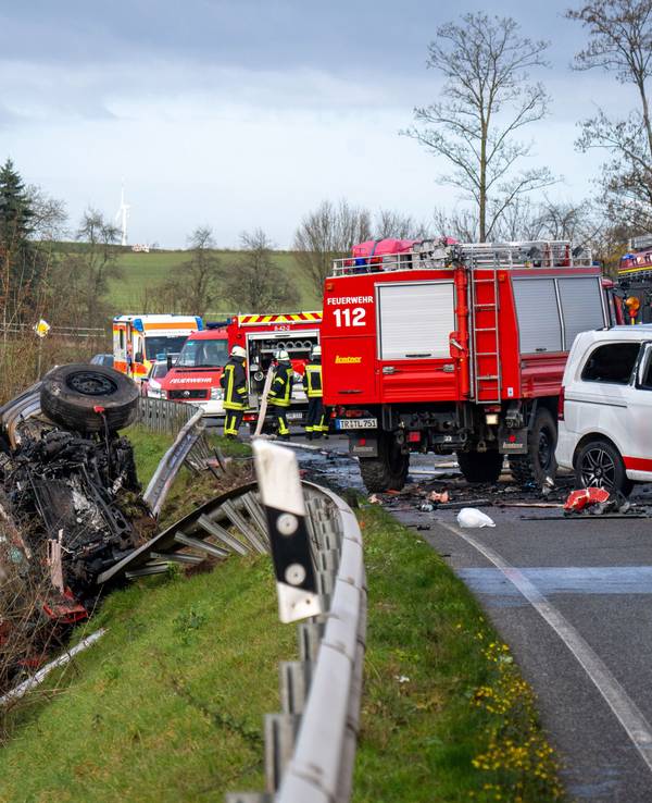 Ein Lastwagen liegt nach einem Frontalzusammenstoß mit einem Kleinbus (r) hinter der Leitplanke an einem Abhang an der Bundesstraße 51 bei Welschbillig.