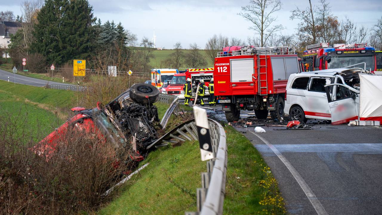 Ein Lastwagen liegt nach einem Frontalzusammenstoß mit einem Kleinbus (r) hinter der Leitplanke an einem Abhang an der Bundesstraße 51 bei Welschbillig.