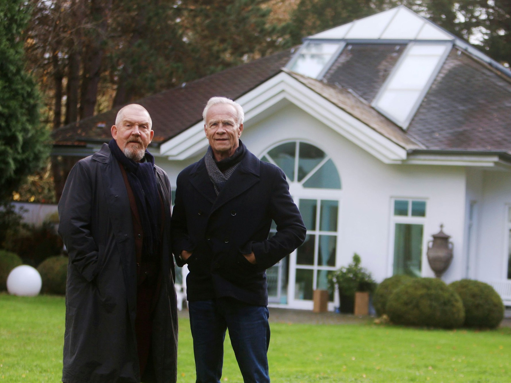Tatort-Dreharbeiten im Villenviertel Hahnwald. Dietmar Bär und Klaus J. Behrendt stehen am Drehort im Garten einer Villa.