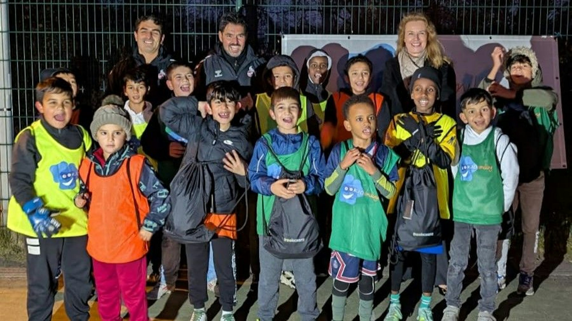 Die Verantwortlichen eines wohltätigen Vereins posieren mit vielen Kindern nach einem Fußballtraining.