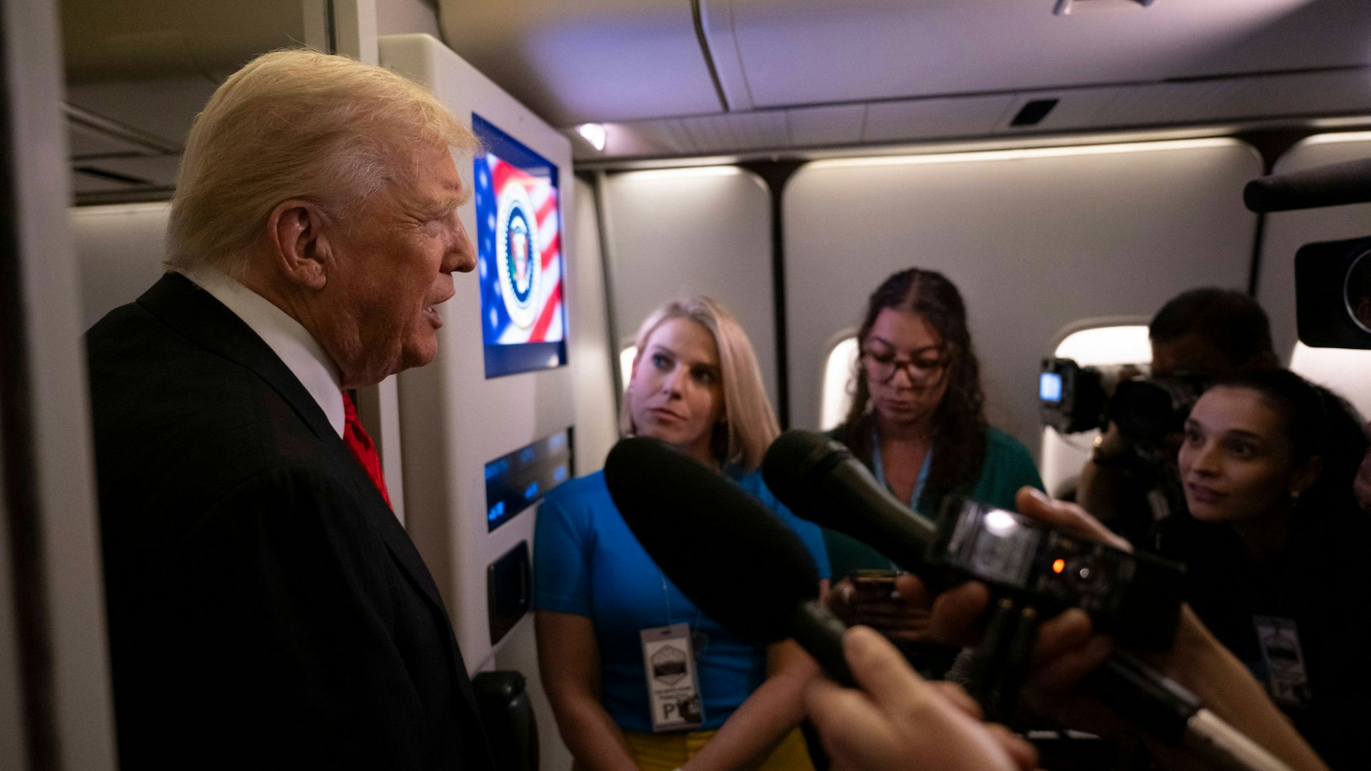 Donald Trump spricht auf einer Pressekonferenz in einem Flugzeug zu Reportern
