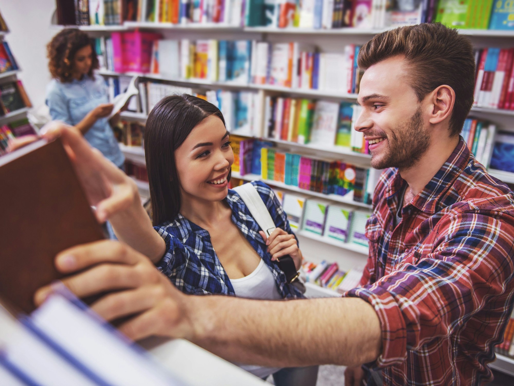 Eine Frau und ein Mann flirten vor einem Bücherregal.
