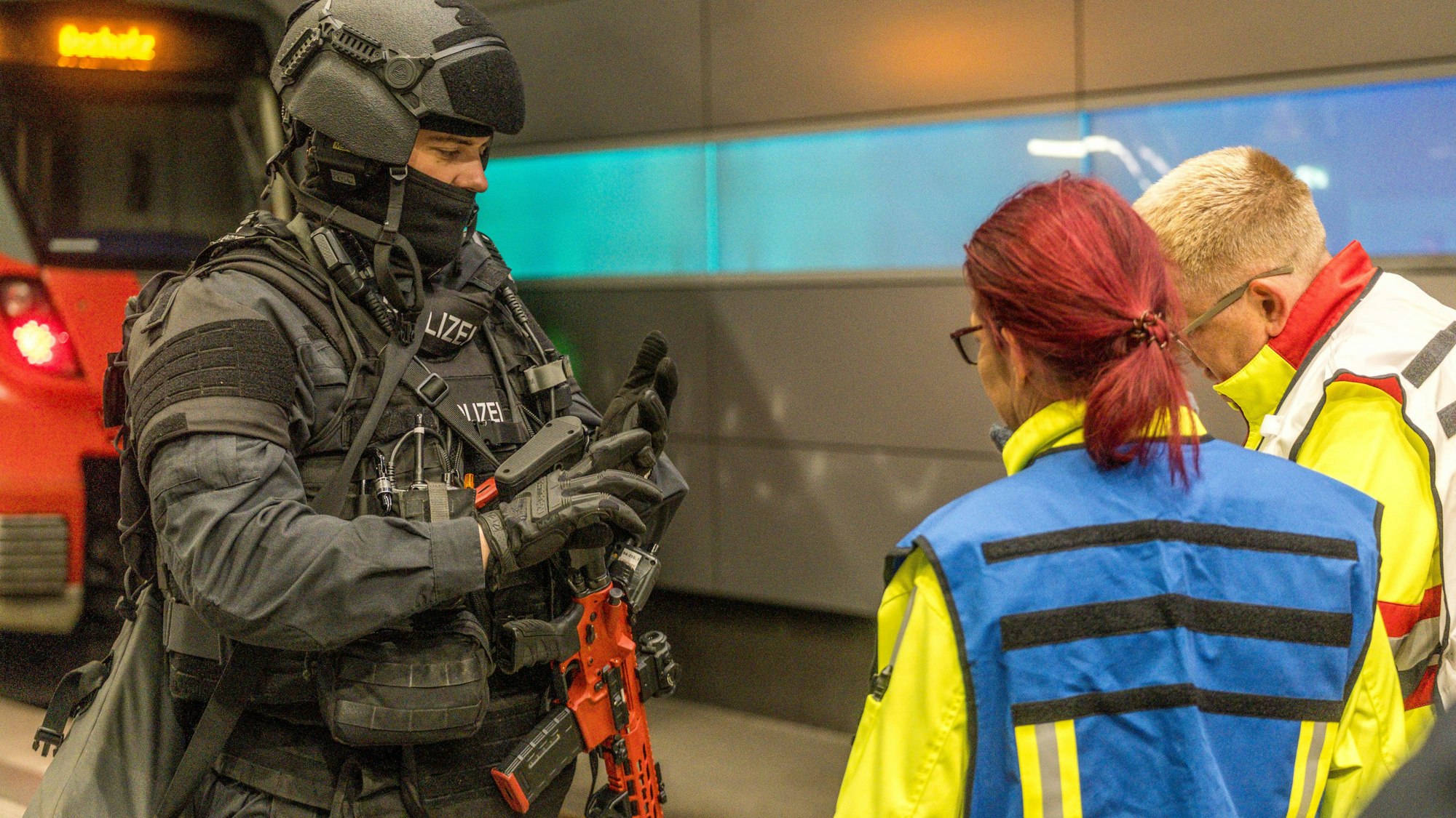 Bundespolizist mit Gewehr spricht mit Rettungskräften bei einer Übung im Bahnhof