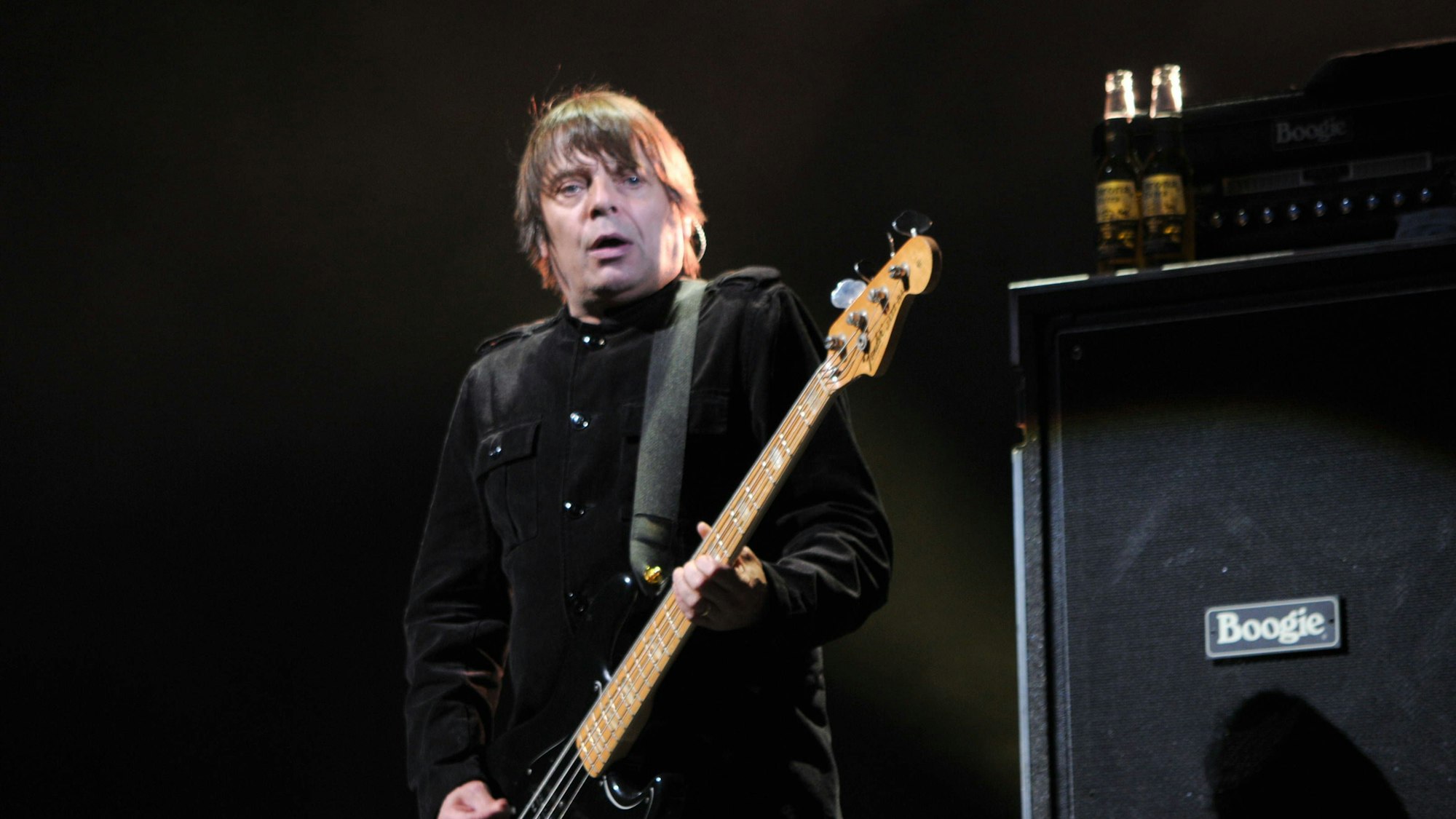 Mani, Bassist der Stone Roses, spielt auf der Bühne seine Bassgitarre vor einem Boogie-Verstärker