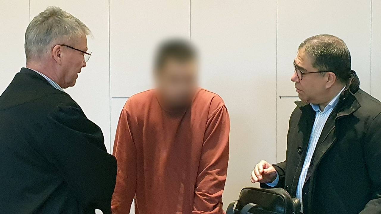 Der Angeklagte (Mitte) steht im Landgericht beim Prozess um den tödlichen Messerangriff in der Krefelder Filiale einer Modekette zwischen seinem Verteidiger Jörg Hintzen (links) und einem Dolmetscher.