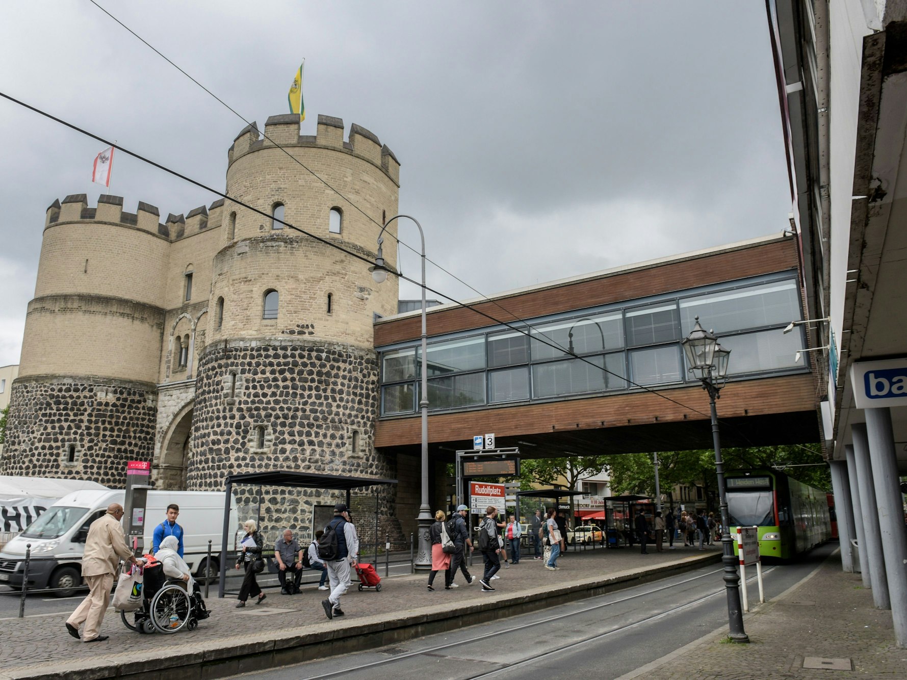 Von einer Burg führt eine überbaute Brücke zu einem weiteren Gebäude.