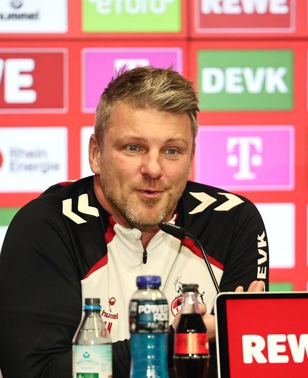 FC-Trainer Lukas Kwasniok grinst schelmisch auf einer Pressekonferenz.