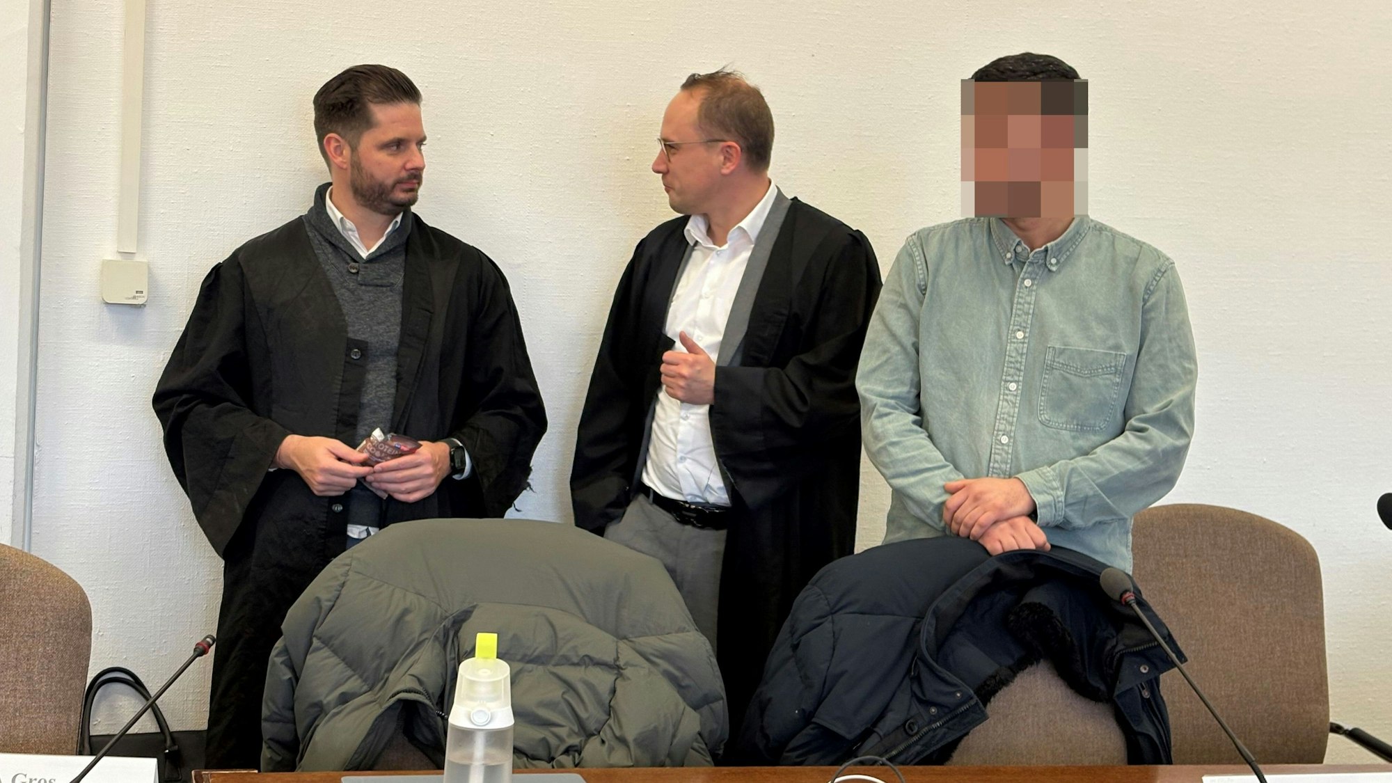 Einer der Angeklagten mit seinen Verteidigern im Landgericht