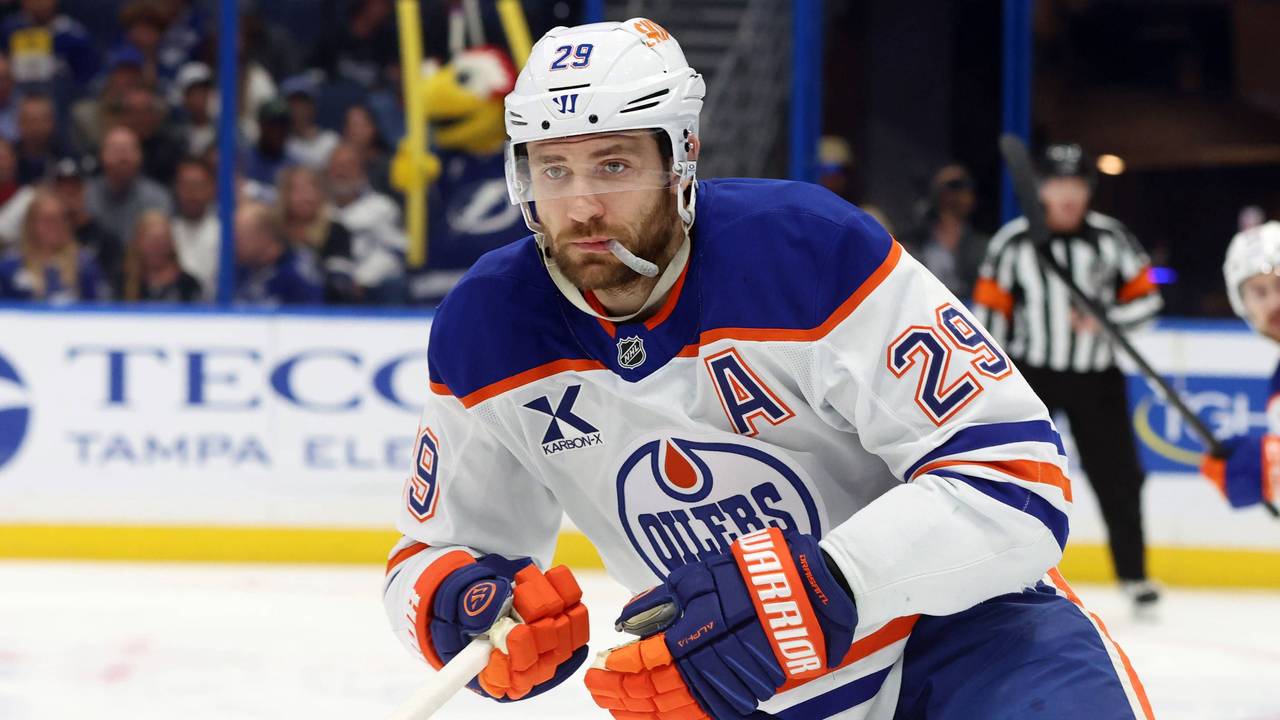Leon Draisaitl in voller Montur auf dem Eis, sein Mundschutz hängt aus dem Mund raus.