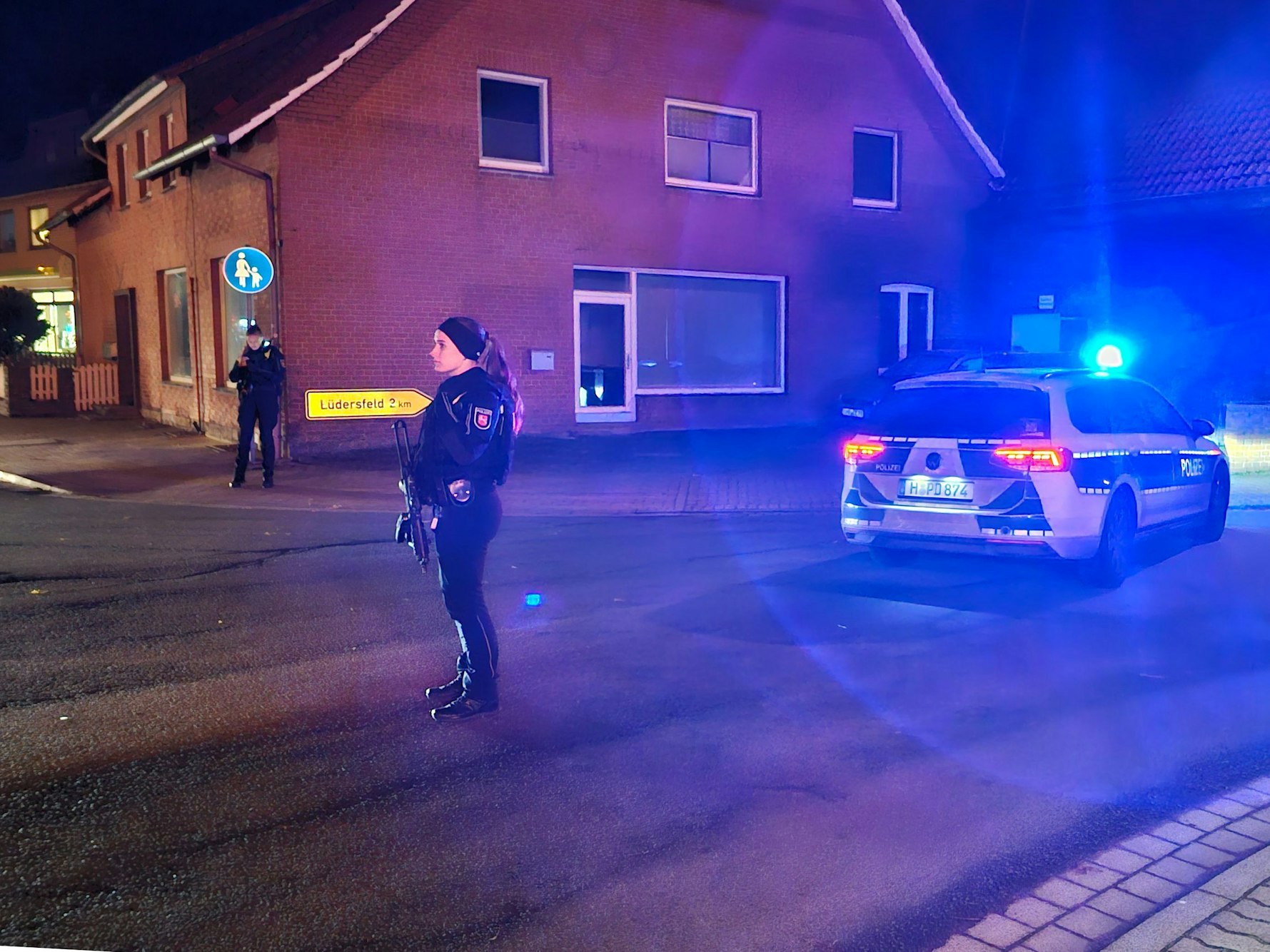 Eine Polizistin sichert neben einem Polizeifahrzeug eine Kreuzung. In der Gemeinde westlich von Hannover seien Schüsse gefallen, verletzt worden sei niemand, teilte eine Polizeisprecherin mit.