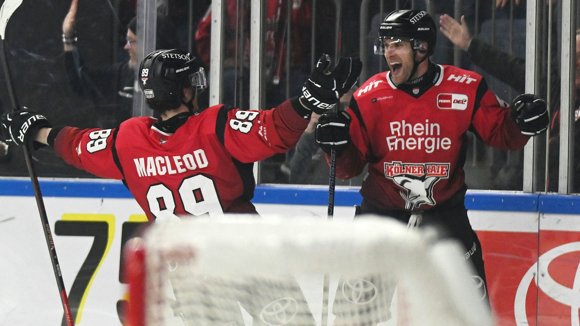 Patrick Russell von den Kölner Haie jubelt mit Gregor Macleod.