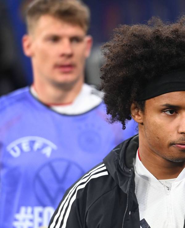 Karim Adeyemi mit schwarzem Stirnband, Lockenkopf und Trainingsjacke, Blick zur Seite gerichtet