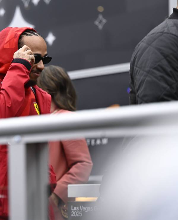 Lewis Hamilton geht in Regenjacke durch das Fahrerlager.