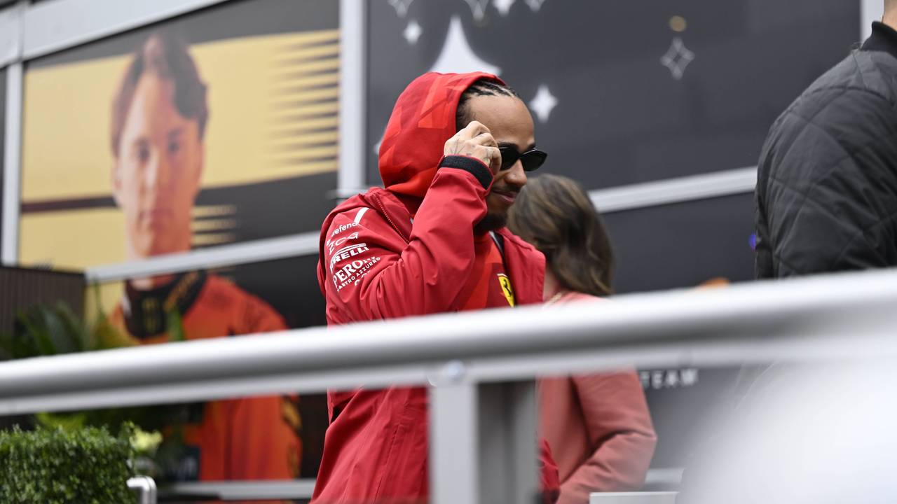 Lewis Hamilton geht in Regenjacke durch das Fahrerlager.