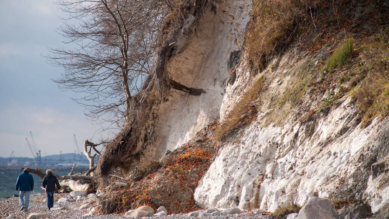 Gesteinsbrocken liegen am Fuße einer Steilküste.