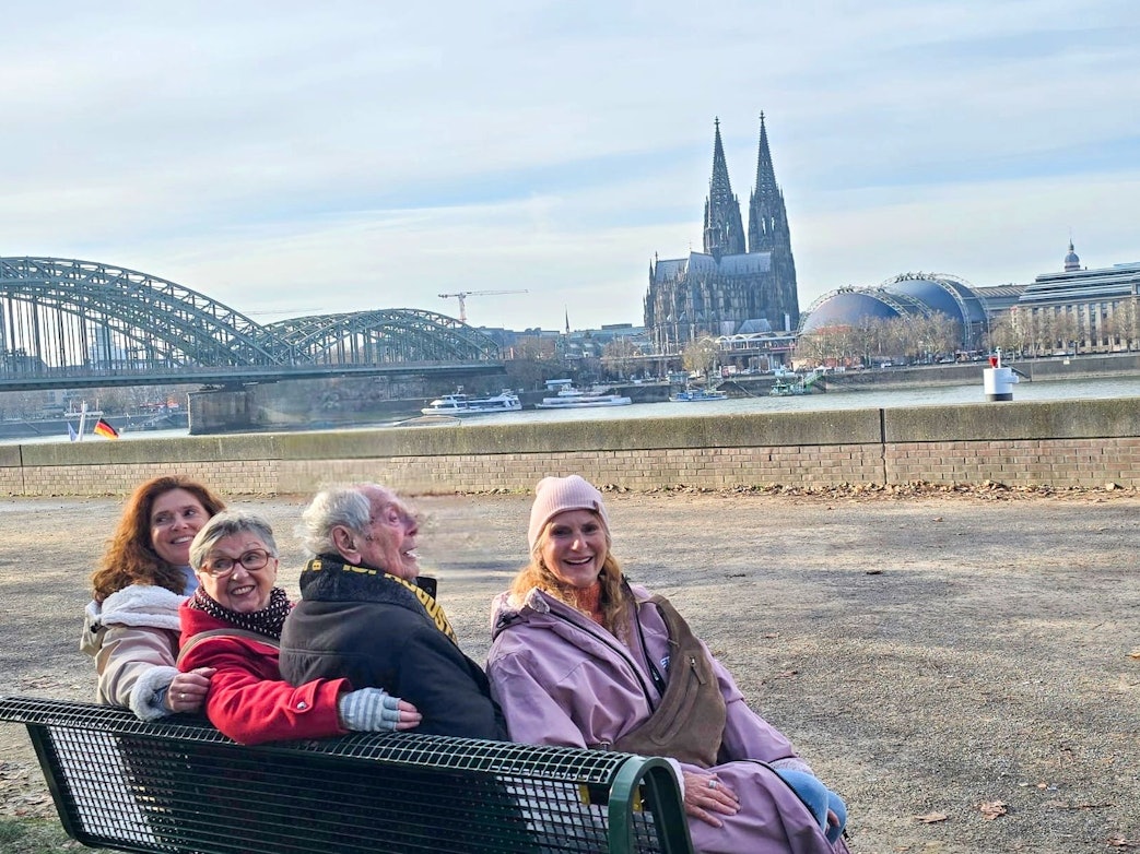 Ludwig Sebus sitzt mit seinen Töchtern Ulla, Monika und Jeannette auf seiner Bank.