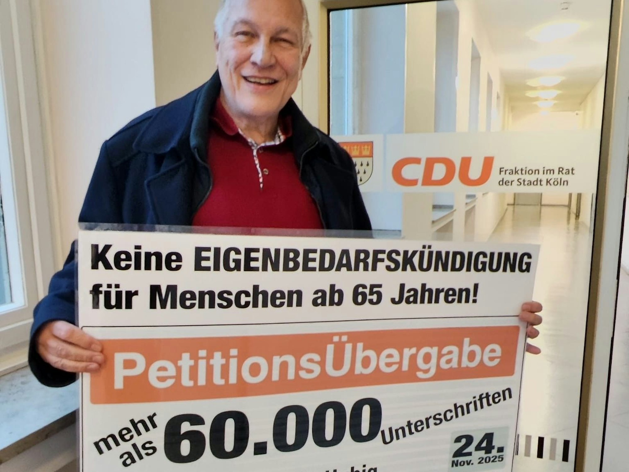 Ein Mann hält ein Plakat in Händen.