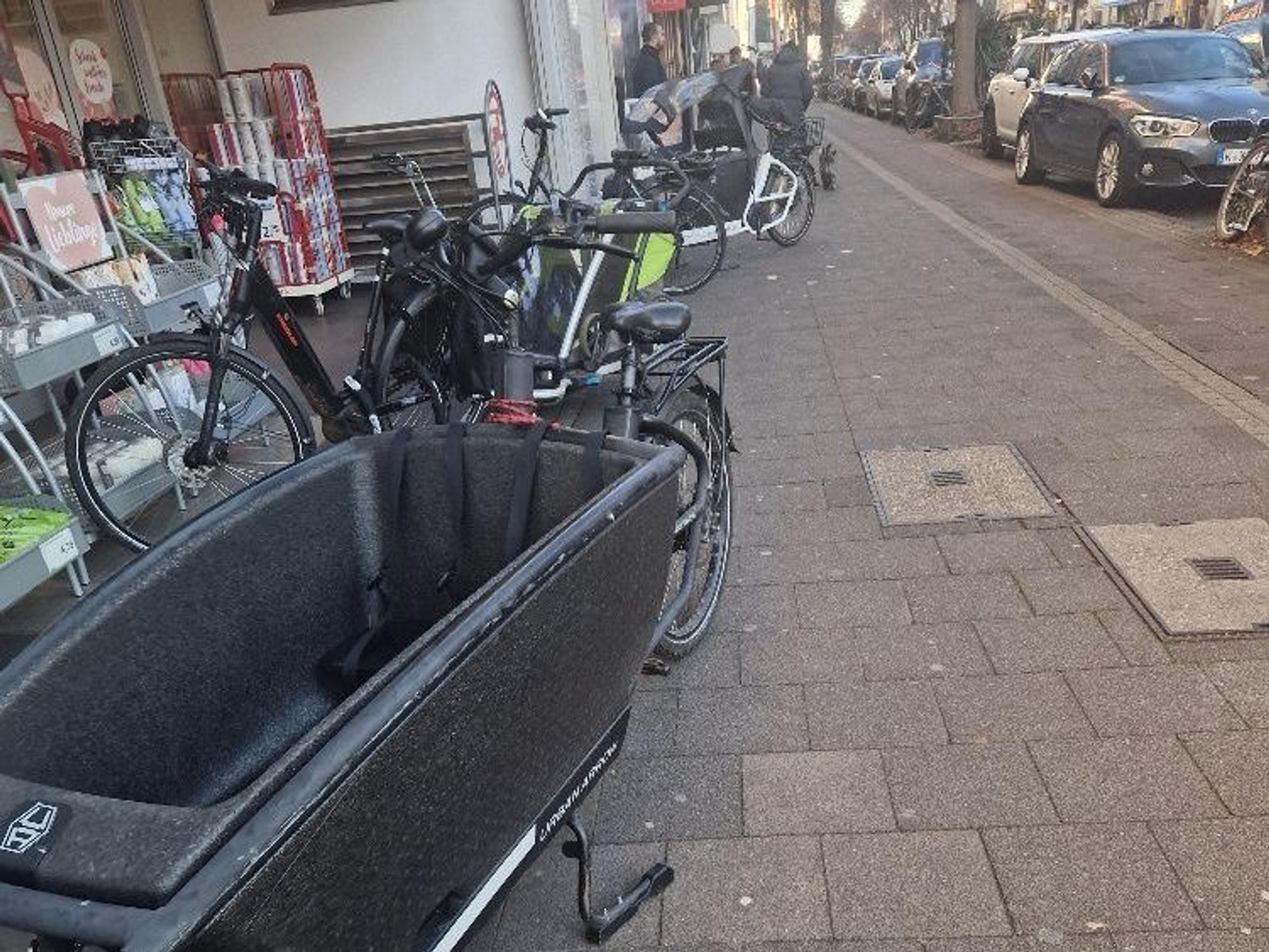 Lastenfahrräder stehen auf dem Bürgersteig in Lindenthal.