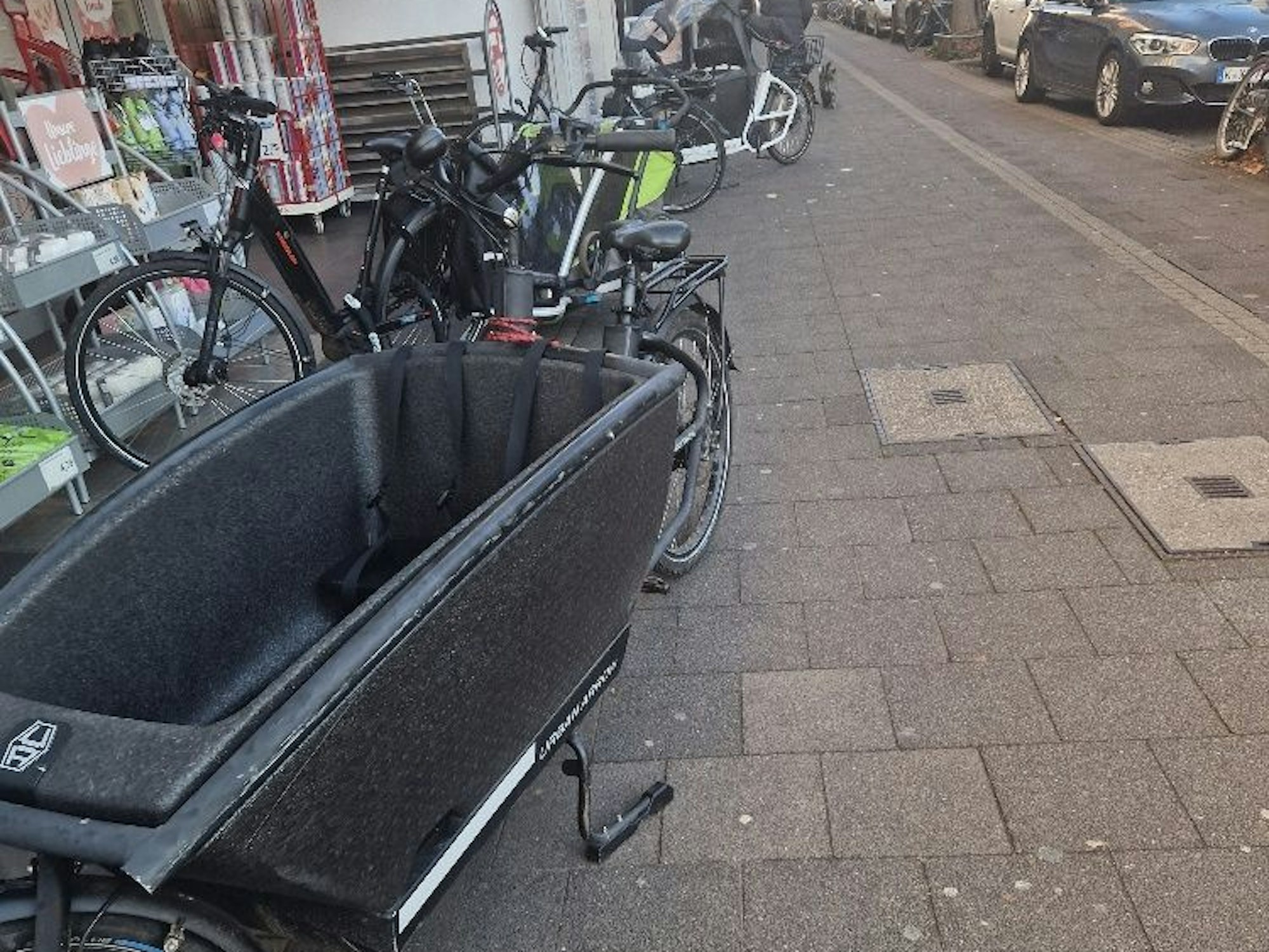 Lastenfahrräder stehen auf einem Bürgersteig.