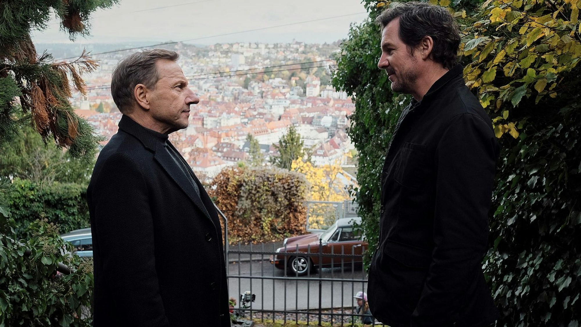 Schöne Stadt, traurige Leben: Die Ermittler Sebastian Bootz (Felix Klare, rechts) und Thorsten Lannert (Richy Müller) diskutieren im „Tatort: Überlebe wenigstens bis morgen“ vor Stuttgarter Kulissen über die Einsamkeit der Jungen. (Bild: SWR/Benoît Linder)