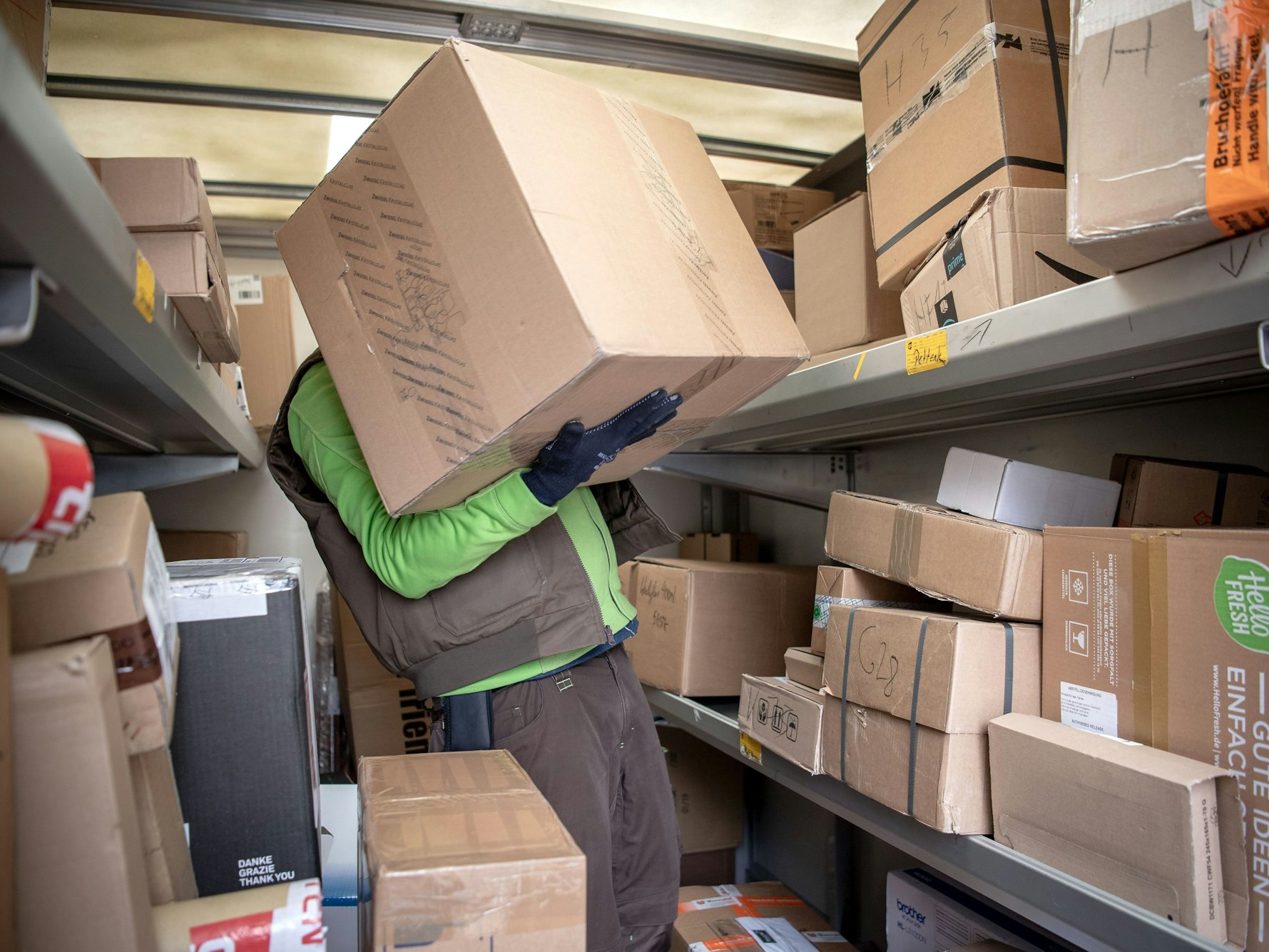 Ein Paketbote lädt Pakete in einen Transporter.