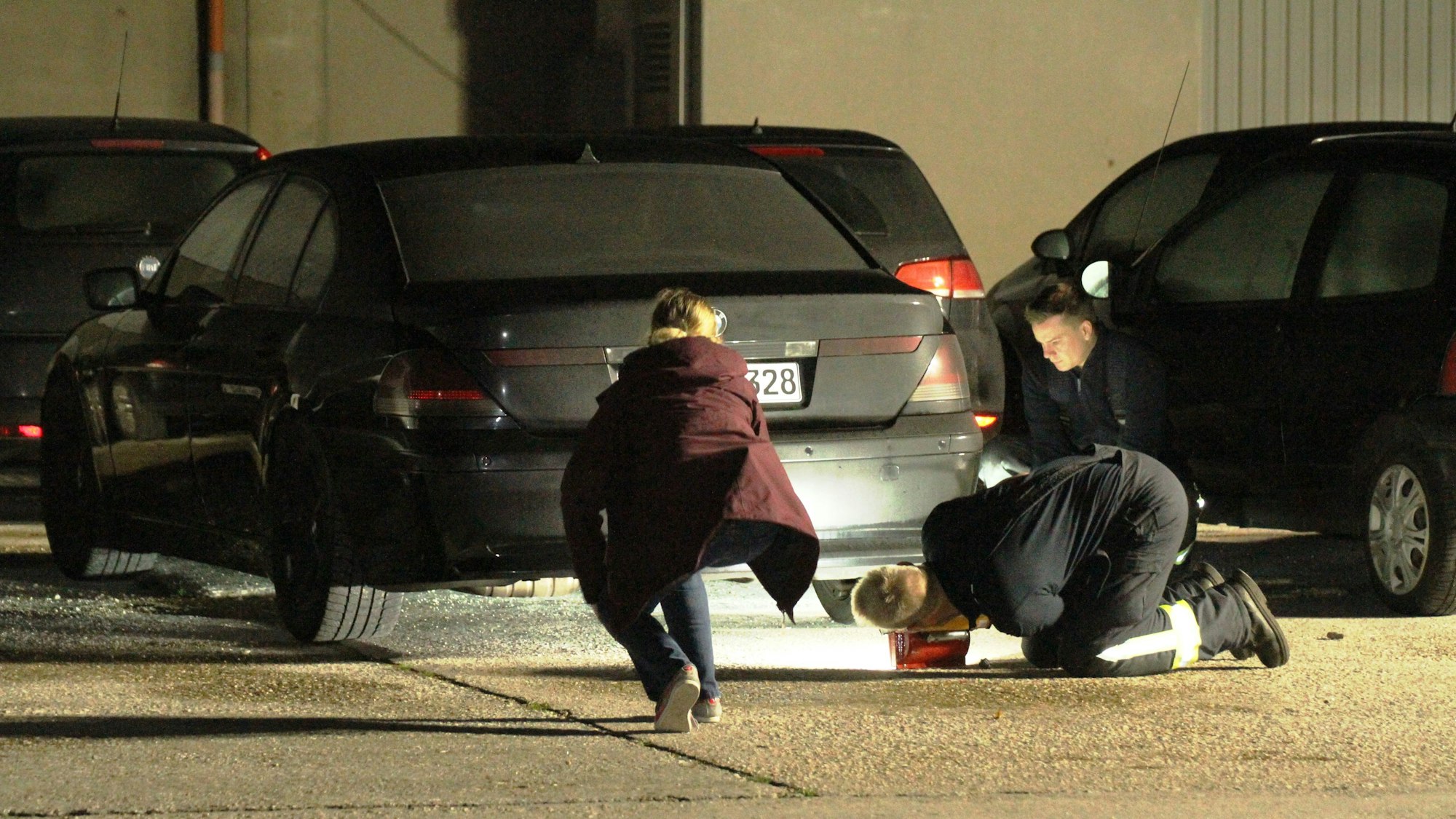 Zwei Polizistinnen gucken unter ein Auto.