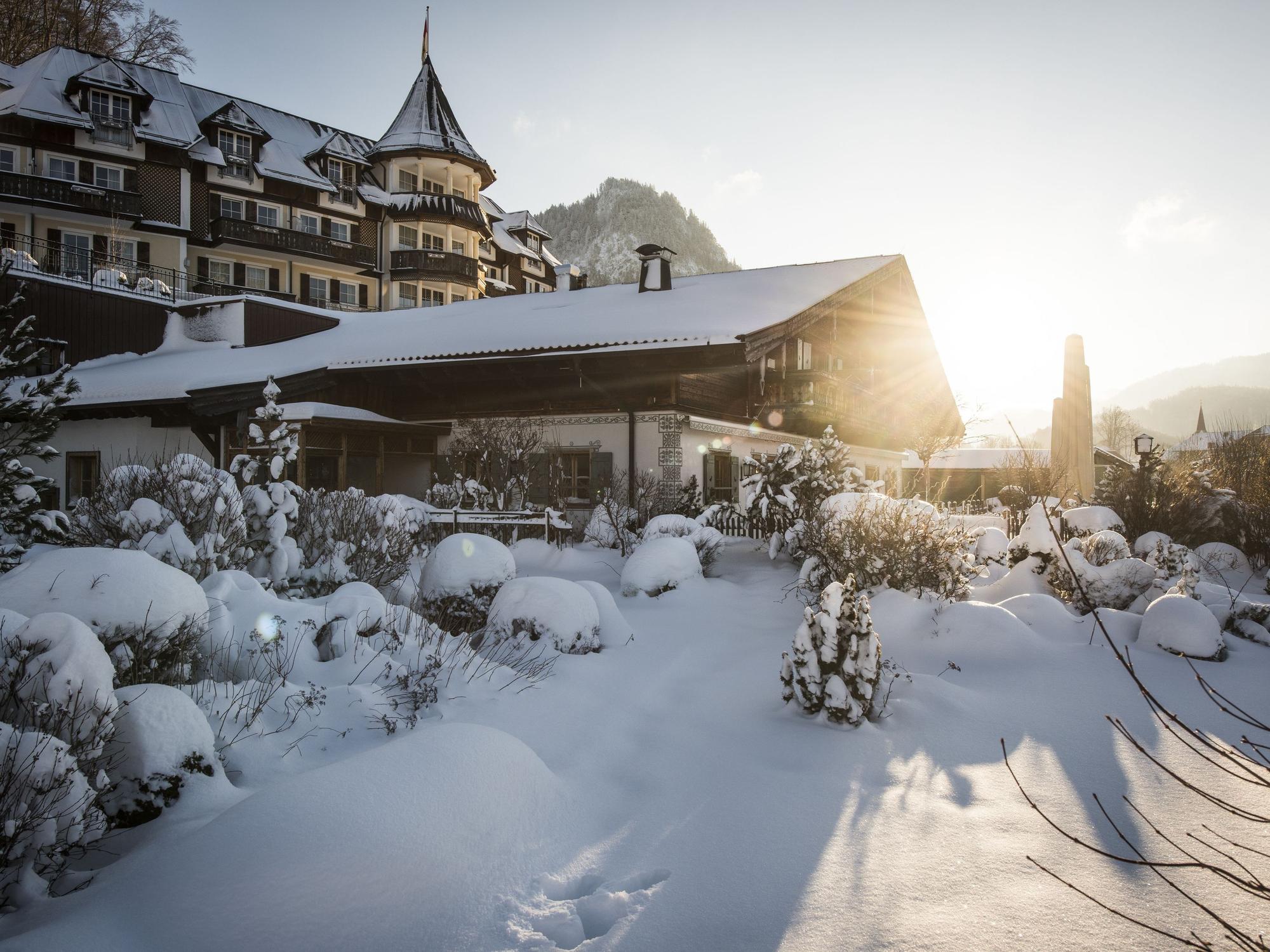 Ein großes Hotel mit romantischem Turm steht inmitten einer tief verschneiten Landschaft