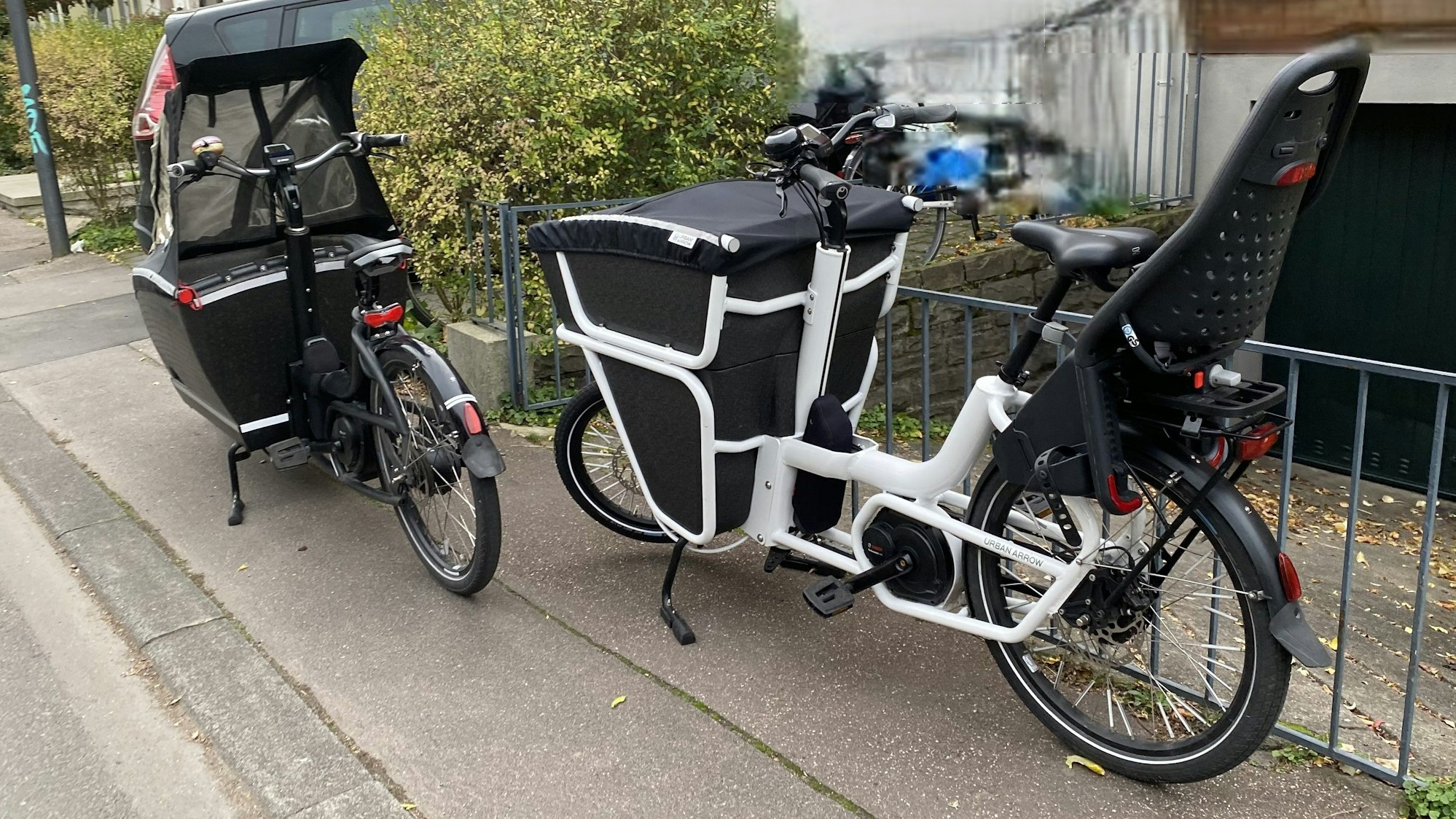 Zwei Lastenräder stehen auf einem Gehweg, sodass kein Durchkommen mehr ist.