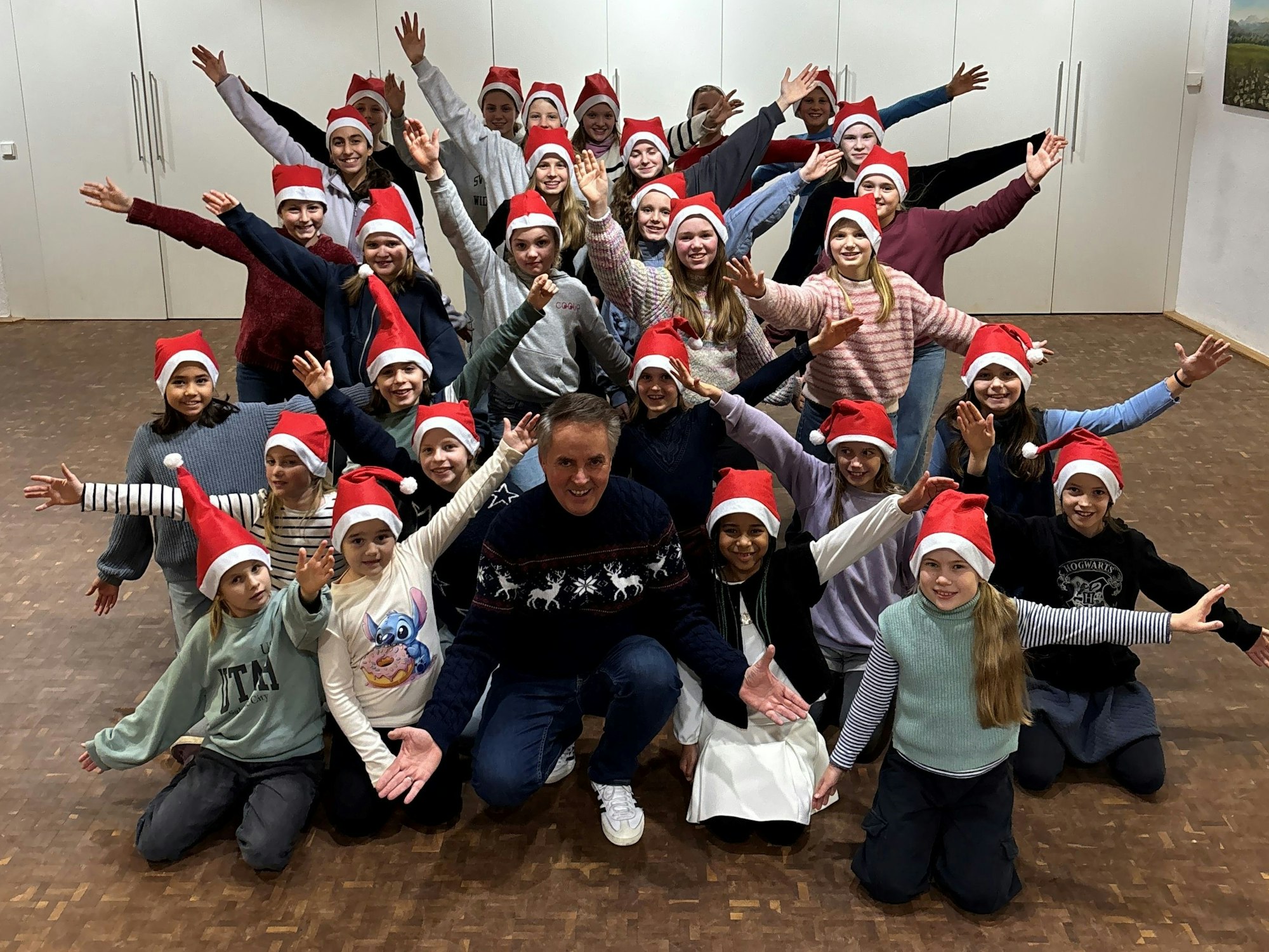Die Lucky Kids mit Weihnachtsmützen auf dem Kopf bei der Chorprobe.