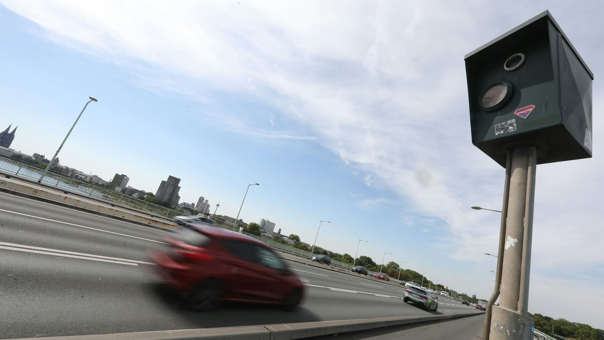 Ein Auto fährt auf der Kölner Zoobrücke an einem Gerät zur Geschiwndigkeitsmessung vorbei.