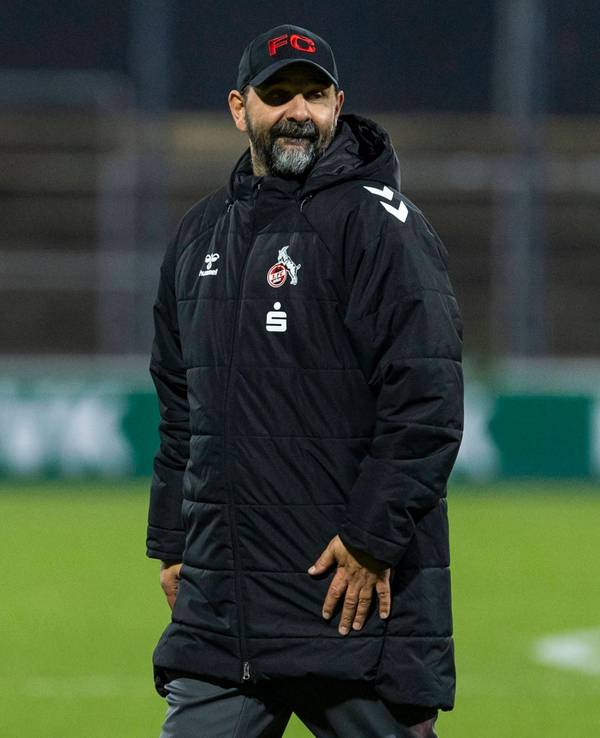 Stefan Ruthenbeck in Wintermantel auf dem Fußballplatz.