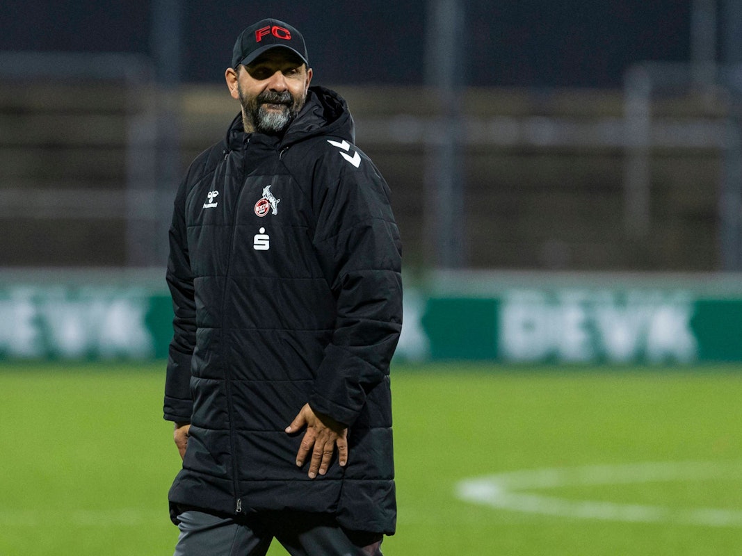 Stefan Ruthenbeck in Wintermantel auf dem Fußballplatz.