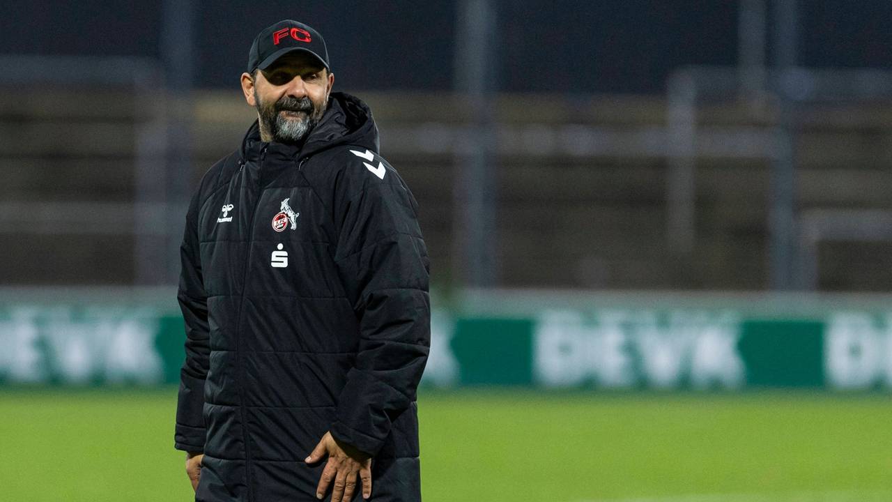 Stefan Ruthenbeck in Wintermantel auf dem Fußballplatz.