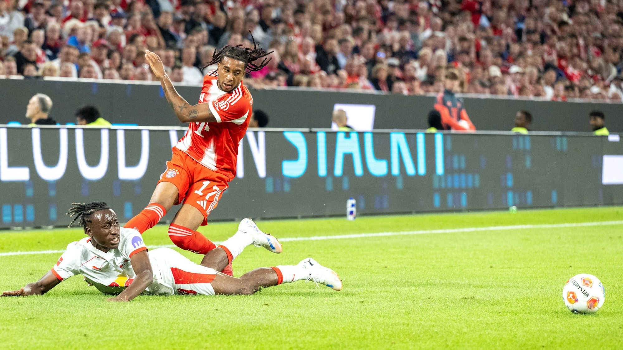 Michael Olise vom FC Bayern dribbelt an Yan Diomande von RB Leipzig vorbei.