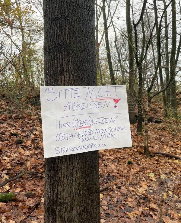 An einem Baum ist ein Schild genagelt, auf dem steht: Bitte nicht abreißen.