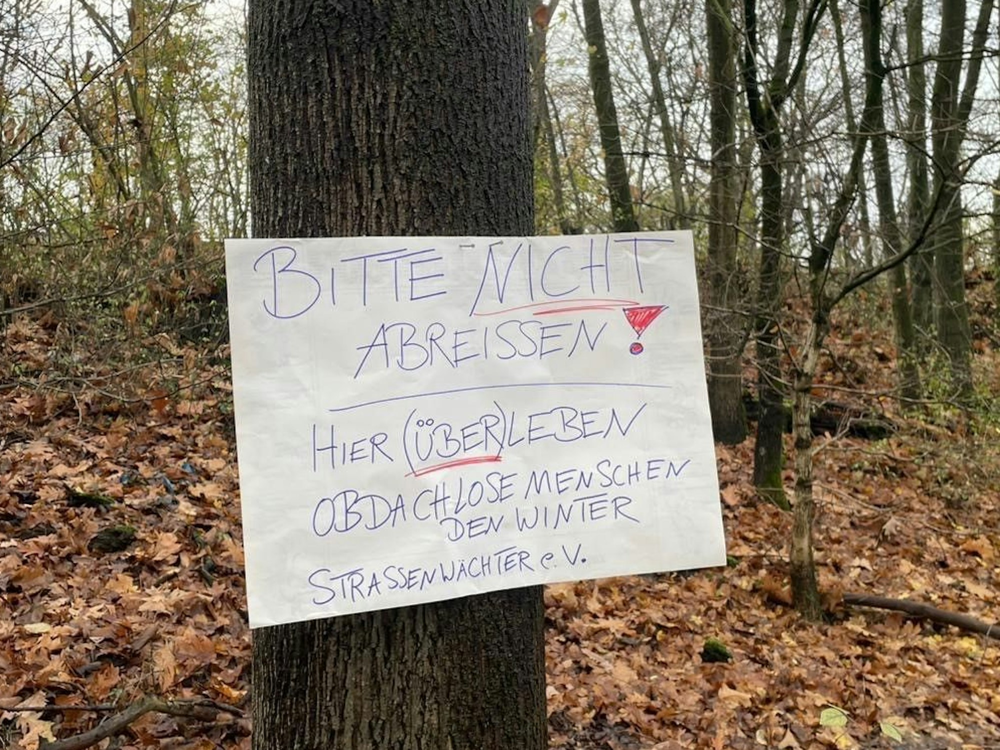 An einem Baum ist ein Schild genagelt, auf dem steht: Bitte nicht abreißen.