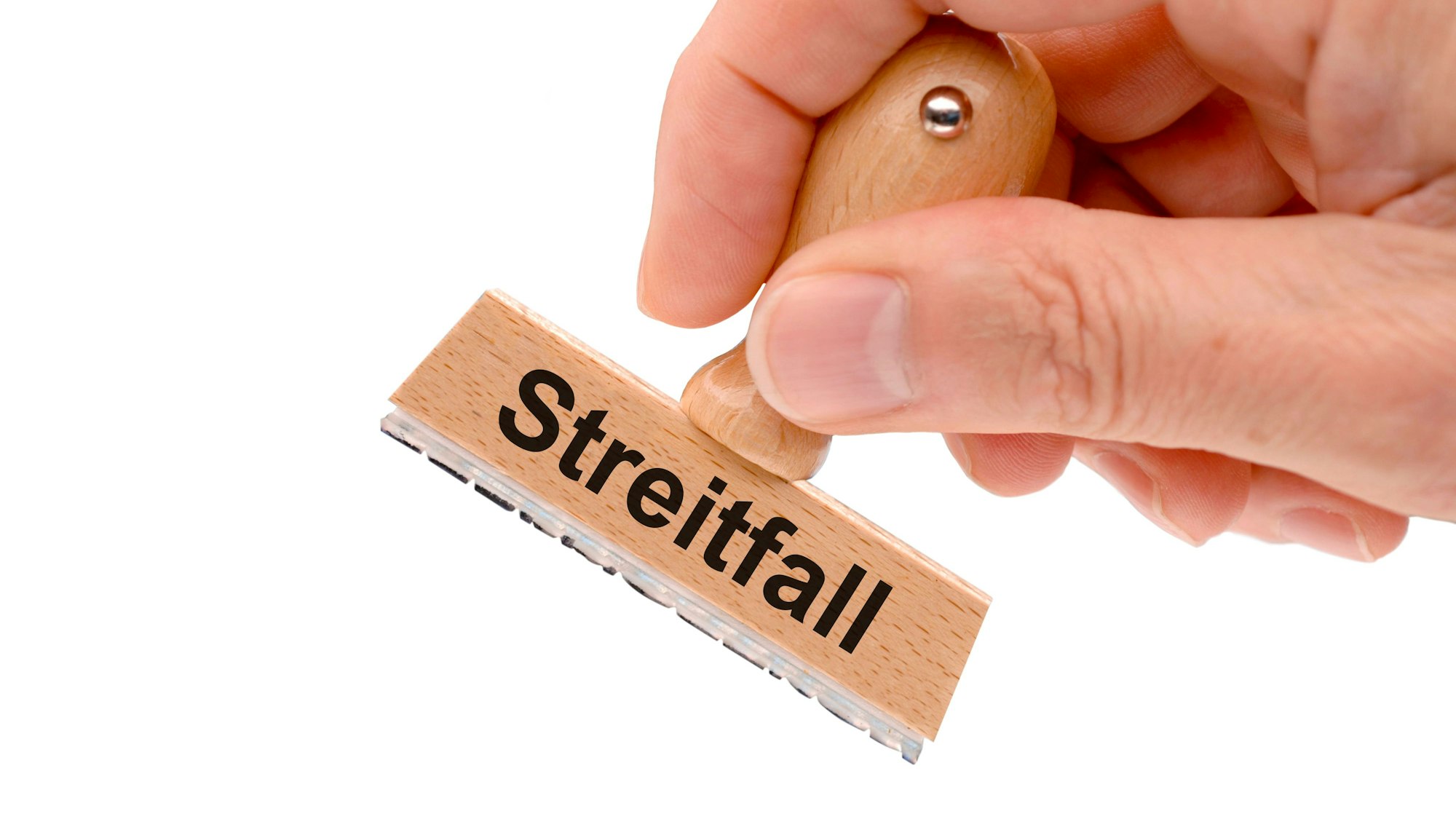 Eine Hand hält einen Holzstempel mit der Aufschrift "Streitfall" auf weißem Hintergrund