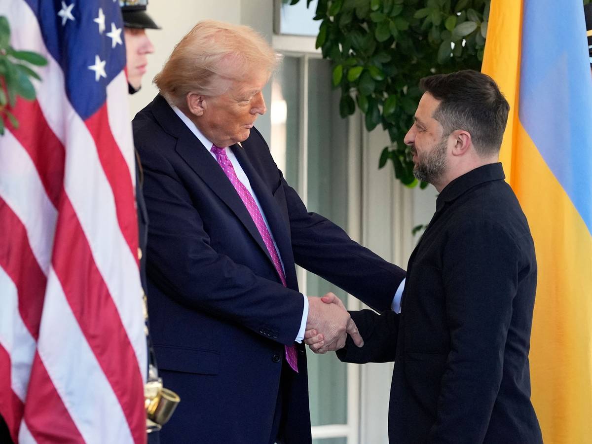 Zwei Männer geben sich die Hand, rechts die ukrainische, links die amerikanische Flagge.